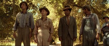 Movie still from “O Brother, Where Art Thou?” (2000), directed by Joel Coen – A couple of men standing next to each other on top of a field; Medium shot, Low angle