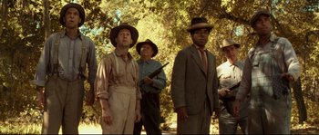 Movie still from “O Brother, Where Art Thou?” (2000), directed by Joel Coen – A group of men standing next to each other in a field; Medium shot, Low angle