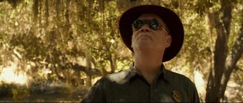Movie still from “O Brother, Where Art Thou?” (2000), directed by Joel Coen – A man wearing a hat and sunglasses in a forest; Close Up shot, Low angle