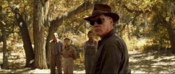 Movie still from “O Brother, Where Art Thou?” (2000), directed by Joel Coen – A group of men standing next to each other in a forest; Medium shot, Over the shoulder angle