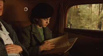 Movie still from “Pan's Labyrinth” (2006), directed by Guillermo del Toro – A woman sitting on a train looking at a book; Medium shot, High angle