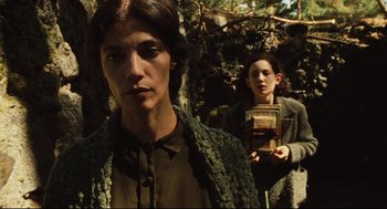 Movie still from “Pan's Labyrinth” (2006), directed by Guillermo del Toro – Two women are standing in the woods holding a book; Medium shot, Low angle
