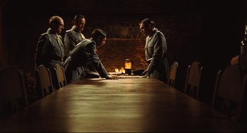 Movie still from “Pan's Labyrinth” (2006), directed by Guillermo del Toro – A group of people sitting around a long wooden table; Wide shot, High angle