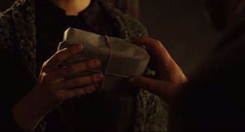Movie still from “Pan's Labyrinth” (2006), directed by Guillermo del Toro – A person is holding a wrapped package in their hands; Close Up shot, High angle