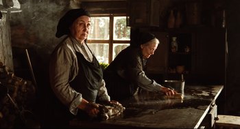 Movie still from “Pan's Labyrinth” (2006), directed by Guillermo del Toro – Two women in a kitchen preparing a meal together; Medium shot, Low angle