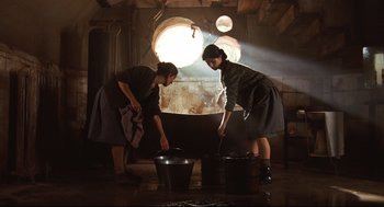 Movie still from “Pan's Labyrinth” (2006), directed by Guillermo del Toro – Two women in a room with buckets of water; Wide shot, Low angle