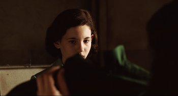 Movie still from “Pan's Labyrinth” (2006), directed by Guillermo del Toro – A young woman looking at the camera while holding onto a jacket; Close Up shot, Over the shoulder angle
