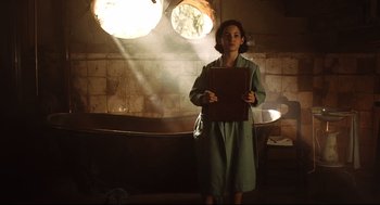 Movie still from “Pan's Labyrinth” (2006), directed by Guillermo del Toro – A woman in a green dress holding a book; Medium shot, Low angle