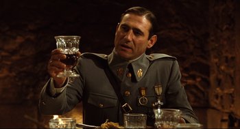 Movie still from “Pan's Labyrinth” (2006), directed by Guillermo del Toro – A man in a military uniform holding a glass of wine; Medium shot, Low angle