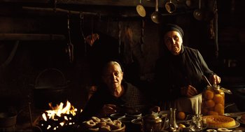 Movie still from “Pan's Labyrinth” (2006), directed by Guillermo del Toro – Two people sitting in front of a fire in a kitchen; Medium shot, Low angle