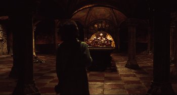 Movie still from “Pan's Labyrinth” (2006), directed by Guillermo del Toro – A man standing in front of a table in a dark room; Wide shot, High angle