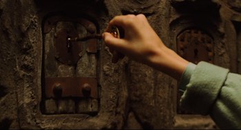 Movie still from “Pan's Labyrinth” (2006), directed by Guillermo del Toro – A hand is holding a key to a door; Extreme Close Up shot, High angle