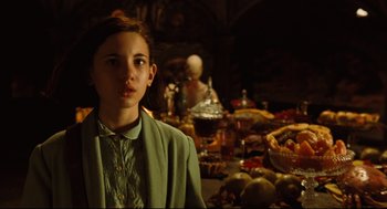 Movie still from “Pan's Labyrinth” (2006), directed by Guillermo del Toro – A young woman standing in front of a table full of food; Medium shot, Over the shoulder angle