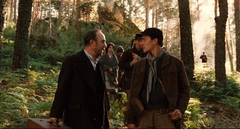 Movie still from “Pan's Labyrinth” (2006), directed by Guillermo del Toro – A group of people standing in the woods talking to each other; Medium shot, Over the shoulder angle