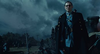 Movie still from “Pan's Labyrinth” (2006), directed by Guillermo del Toro – A man dressed in military clothing standing in front of power lines; Medium shot, Low angle