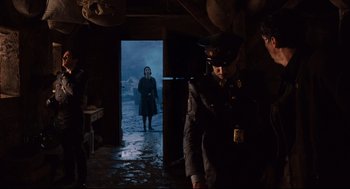 Movie still from “Pan's Labyrinth” (2006), directed by Guillermo del Toro – A man and a woman in uniform in a dark room; Wide shot, Low angle
