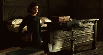 Movie still from “Pan's Labyrinth” (2006), directed by Guillermo del Toro – A woman standing in front of a bed in a dark room; Medium shot, High angle