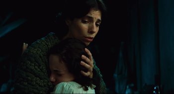 Movie still from “Pan's Labyrinth” (2006), directed by Guillermo del Toro – A woman holding a child in her arms in a dark room; Close Up shot, Low angle