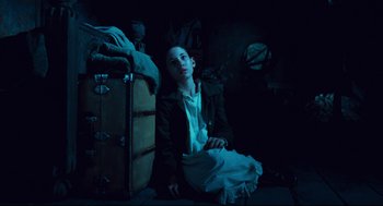 Movie still from “Pan's Labyrinth” (2006), directed by Guillermo del Toro – A woman sitting on the ground in a dark room; Medium shot, High angle