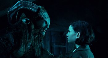 Movie still from “Pan's Labyrinth” (2006), directed by Guillermo del Toro – A woman standing next to an animal with horns on it's head; Close Up shot, Over the shoulder angle