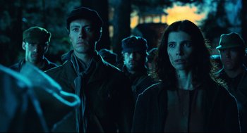 Movie still from “Pan's Labyrinth” (2006), directed by Guillermo del Toro – A group of people standing next to each other in the dark; Medium shot, Low angle