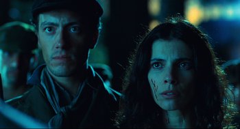 Movie still from “Pan's Labyrinth” (2006), directed by Guillermo del Toro – A man and a woman looking at the camera in the dark; Close Up shot, Low angle