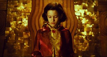 Movie still from “Pan's Labyrinth” (2006), directed by Guillermo del Toro – A woman in a red and gold dress sitting in a chair; Medium shot, High angle