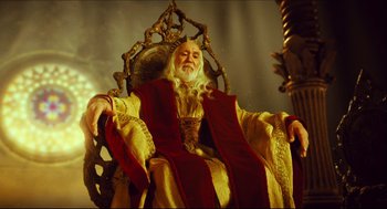 Movie still from “Pan's Labyrinth” (2006), directed by Guillermo del Toro – An old man sitting in a chair wearing a robe; Medium shot, Low angle