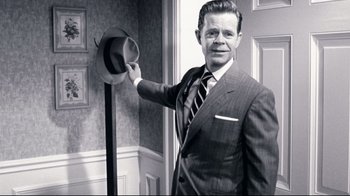 Movie still from “Pleasantville” (1998), directed by Gary Ross – A black and white photo of a man holding a hat; Medium shot, Over the shoulder angle