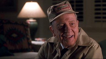 Movie still from “Pleasantville” (1998), directed by Gary Ross – An older man wearing a hat and smiling for the camera; Close Up shot, Low angle