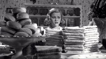 Movie still from “Pleasantville” (1998), directed by Gary Ross – A woman looking at a stack of sandwiches; Medium shot, Low angle