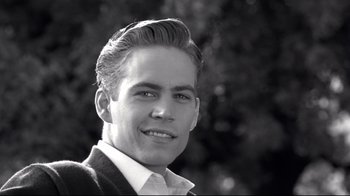 Movie still from “Pleasantville” (1998), directed by Gary Ross – Black and white photograph of a young man smiling for the camera; Close Up shot, Over the shoulder angle