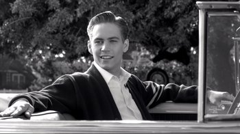 Movie still from “Pleasantville” (1998), directed by Gary Ross – Black and white photograph of a young man smiling; Medium shot, Over the shoulder angle