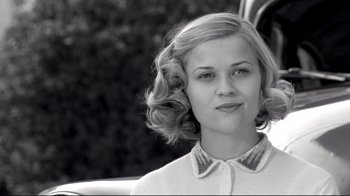 Movie still from “Pleasantville” (1998), directed by Gary Ross – A black - and - white photo of a woman in a car; Close Up shot, Over the shoulder angle