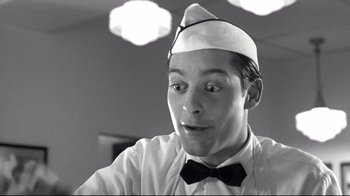 Movie still from “Pleasantville” (1998), directed by Gary Ross – A man wearing a hat and a bow tie; Close Up shot, Low angle