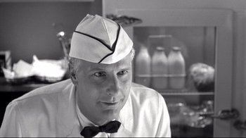 Movie still from “Pleasantville” (1998), directed by Gary Ross – A black and white photo of a man wearing a hat and a bow tie; Close Up shot, Low angle