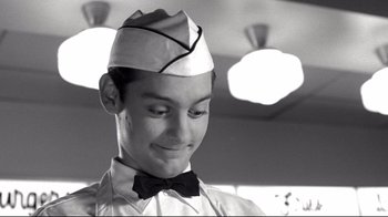 Movie still from “Pleasantville” (1998), directed by Gary Ross – A young man wearing a hat and a bow tie; Close Up shot, Low angle