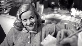 Movie still from “Pleasantville” (1998), directed by Gary Ross – A black and white photo of a woman smiling at the camera; Close Up shot, Over the shoulder angle