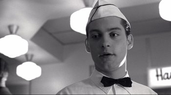 Movie still from “Pleasantville” (1998), directed by Gary Ross – A man wearing a bow tie and a hat; Close Up shot, Low angle