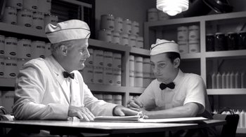 Movie still from “Pleasantville” (1998), directed by Gary Ross – A couple of men sitting at a table in a room; Medium shot, Over the shoulder angle
