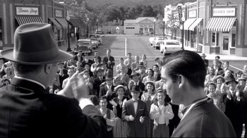 Movie still from “Pleasantville” (1998), directed by Gary Ross – A group of people standing on the side of the street; Wide shot, High angle
