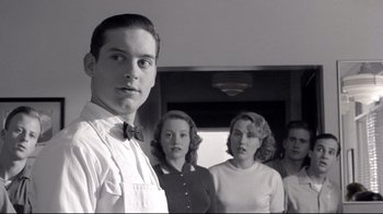 Movie still from “Pleasantville” (1998), directed by Gary Ross – A man standing in front of a group of women; Medium shot, Low angle