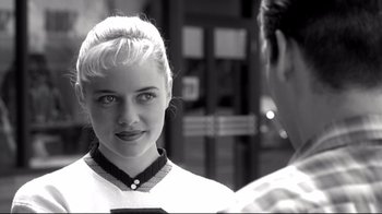 Movie still from “Pleasantville” (1998), directed by Gary Ross – A young woman looking at a man in front of a building; Close Up shot, Over the shoulder angle