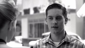 Movie still from “Pleasantville” (1998), directed by Gary Ross – Black and white photograph of a young man in a plaid shirt; Close Up shot, Over the shoulder angle