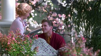 Movie still from “Pleasantville” (1998), directed by Gary Ross – A man and a woman holding an open umbrella; Medium shot, Over the shoulder angle
