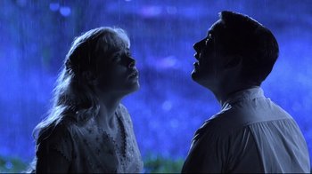 Movie still from “Pleasantville” (1998), directed by Gary Ross – A man and a woman standing in the rain looking at each other; Medium shot, Low angle