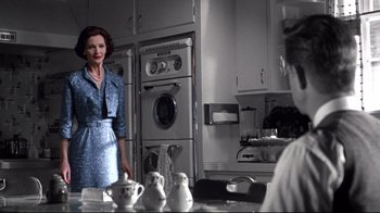Movie still from “Pleasantville” (1998), directed by Gary Ross – A woman standing in front of a stove in a kitchen; Medium shot, Over the shoulder angle