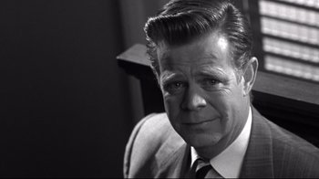 Movie still from “Pleasantville” (1998), directed by Gary Ross – Black and white photograph of a man in a suit and tie; Close Up shot, Over the shoulder angle