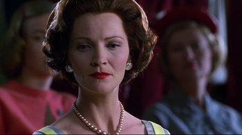 Movie still from “Pleasantville” (1998), directed by Gary Ross – An older woman wearing pearls and a yellow dress; Close Up shot, Low angle