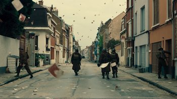 Movie still from “Dunkirk” (2017), directed by Christopher Nolan – A group of people walking down a street; Extreme Wide shot, High angle